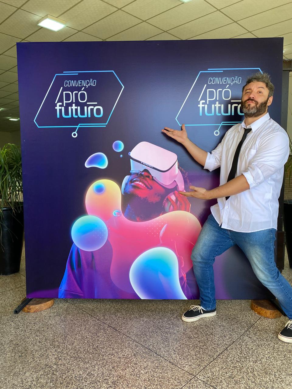 Pedro Prudente posando ao lado do backdrop oficial da Convenção Pró Futuro